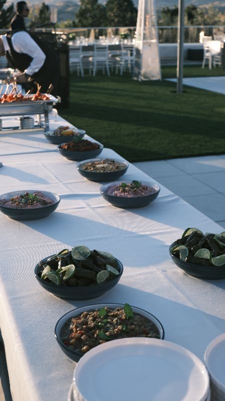 Bowls of meze and salads along a buffet at a Bora event